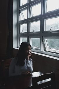 Thoughtful young woman sitting in classroom