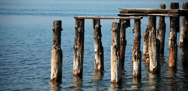 Close-up of wooden posts in sea