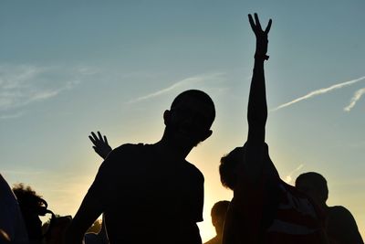 Silhouette people standing against sky during sunset