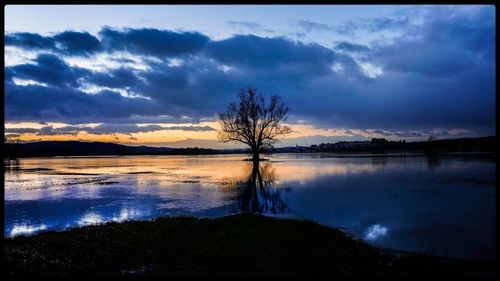 Scenic view of lake against cloudy sky