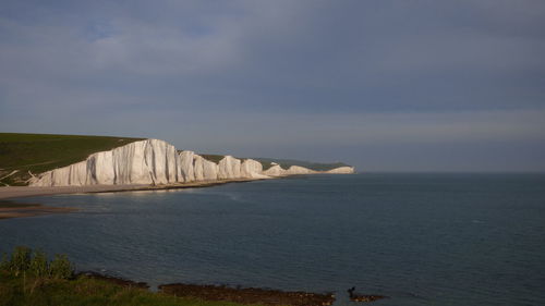 Scenic view of sea by beachy head against sky
