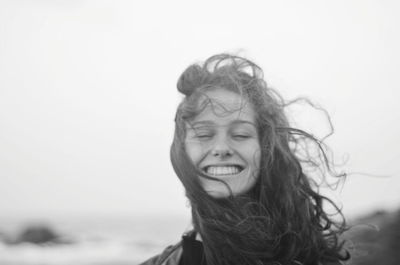 Portrait of smiling woman against sky
