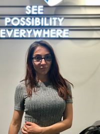 Portrait of smiling young woman standing against text