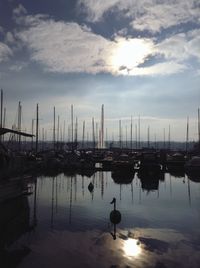 Boats moored at harbor against sky during sunset