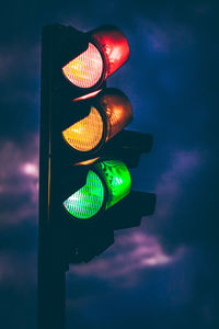 Illuminated road sign against sky