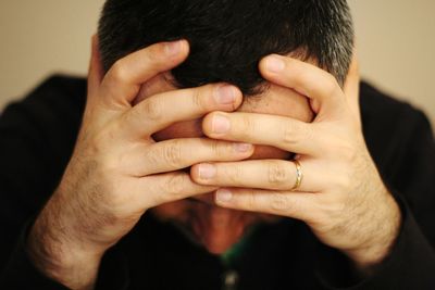 Close-up of man with head in hands