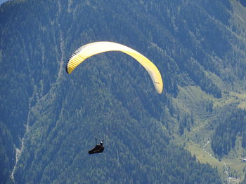 Person paragliding over mountain