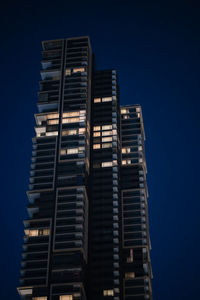 Low angle view of modern buildings against blue sky
