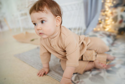 Portrait of cute baby boy lying on bed at home