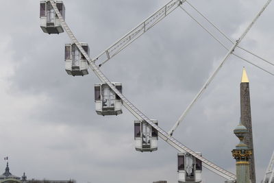 Low angle view of cranes at construction site against sky