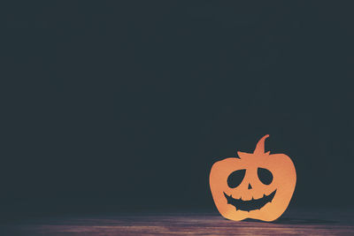 View of red pumpkin against black background