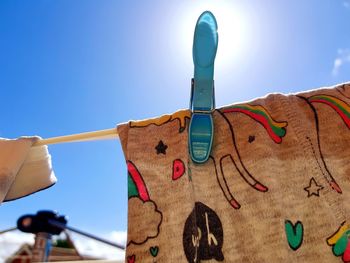 Low angle view of clothes hanging against blue sky