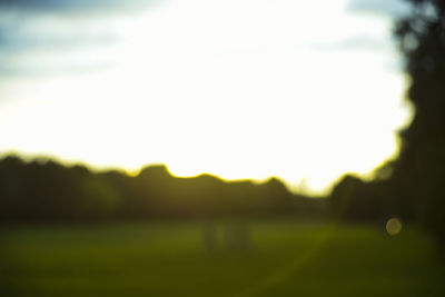 Defocused image of field against sky during sunset