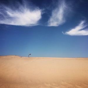 Scenic view of desert against blue sky