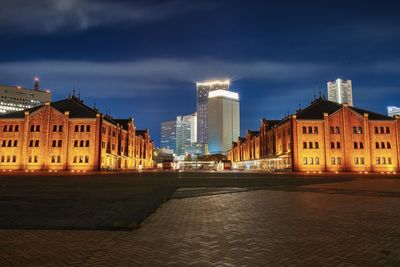 Illuminated city buildings against sky at dusk