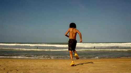 Rear view of woman standing on beach