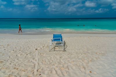 Deck chair at beach against sky