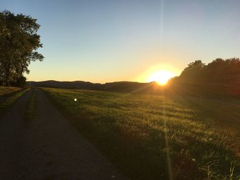 Scenic view of field against clear sky during sunset