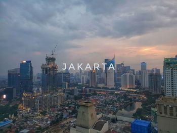 Aerial view of modern buildings in city against sky during sunset