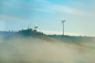 Windmill on field against sky