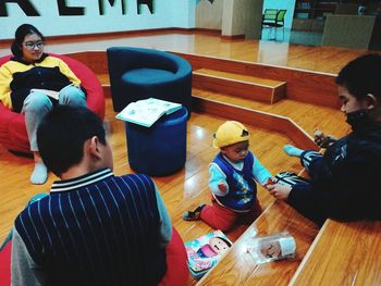 High angle view of people sitting on table