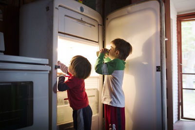 Boys taking food from fridge