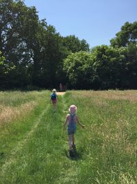 Rear view of children running on field