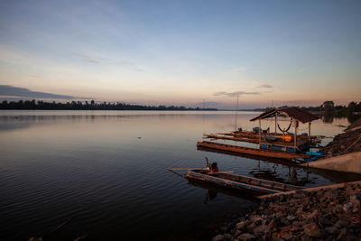 Fishing boats in sea at sunset