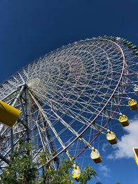 Low angle view of ferris wheel against blue sky