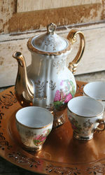 Close-up of teapot and cups in plate