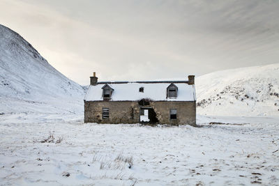 Built structure on snow covered land against sky