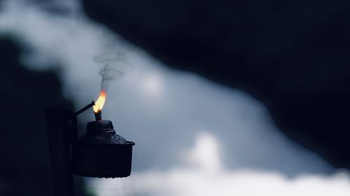 Close-up of hand holding burning candle