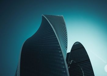 Low angle view of skyscrapers against blue sky