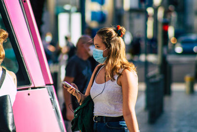 Young woman using mobile phone in city