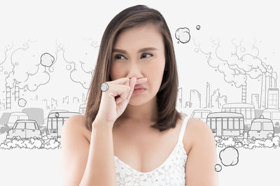 Woman with cold and flu standing against wall