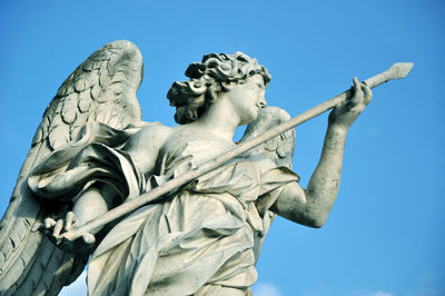 Low angle view of angel statue against clear blue sky