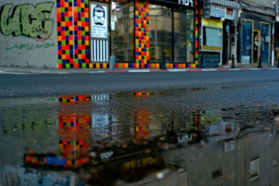 Reflection of building in puddle on road