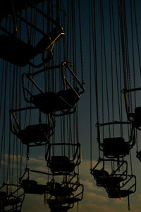 Low angle view of silhouette swing ride during sunset