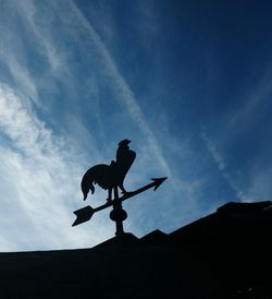 Low angle view of silhouette statue against sky