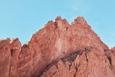 Low angle view of red rocks against a clear blue sky