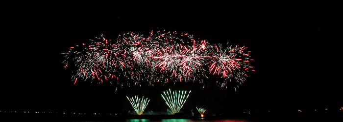 Low angle view of firework display at night