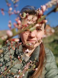 Portrait of young woman with red flowering plants