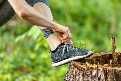 Midsection of man standing by tree against plants