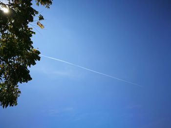 Low angle view of vapor trail against clear blue sky