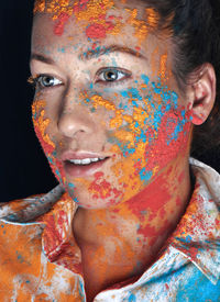 Close-up portrait of a young woman with holi