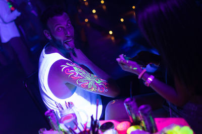 Man sticking on tongue in nightclub