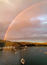 Scenic view of rainbow over sea against sky