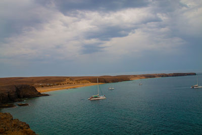 Sailboats in sea against sky