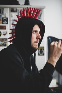 Portrait of punk man smoking against stickers wall