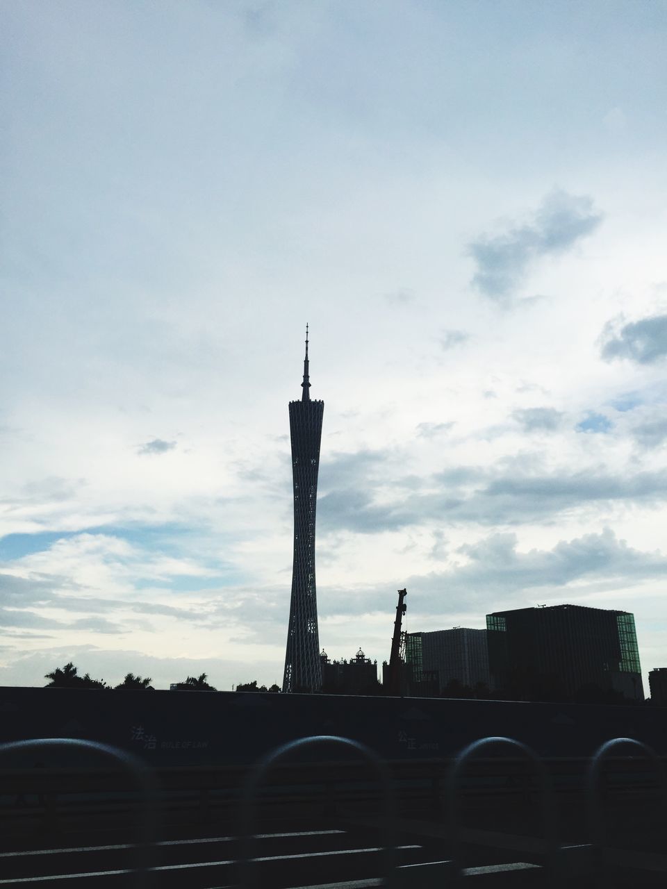 architecture, built structure, sky, building exterior, transportation, cloud - sky, low angle view, car, cloud, city, road, land vehicle, street, cloudy, outdoors, mode of transport, building, day, street light, no people